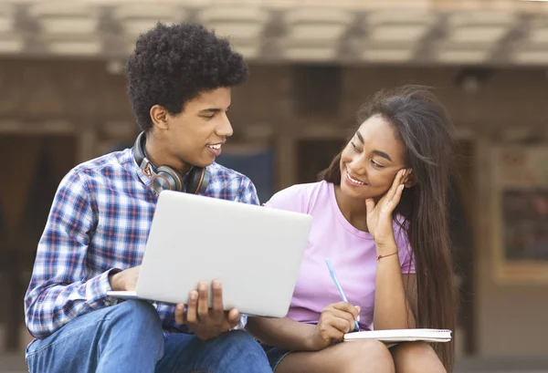 Jeunes étudiants africains travaillant sur un ordinateur portable ensemble à l'extérieur — Photo