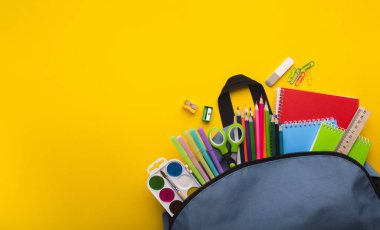Sarı arka plan üzerinde içinde kırtasiye ile Sırt Çantası