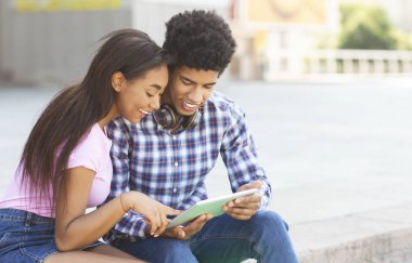 Birlikte dijital tablet kullanarak neşeli Afrikalı gençler