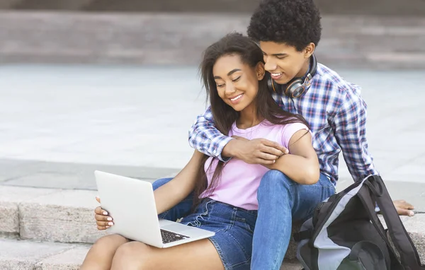 Par tonåringar i kärlek med laptop utomhus tillsammans — Stockfoto