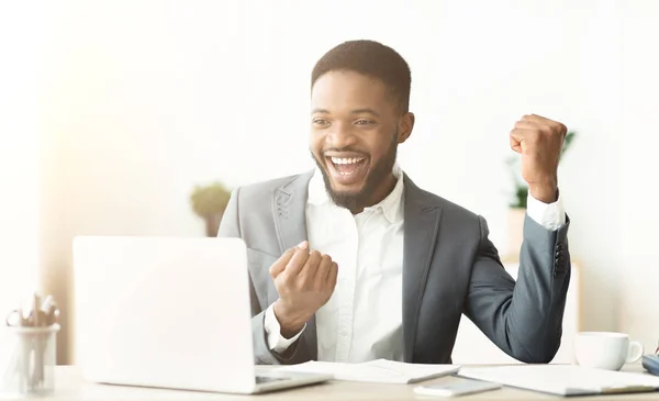 Excited African American worker celebrating finishing project