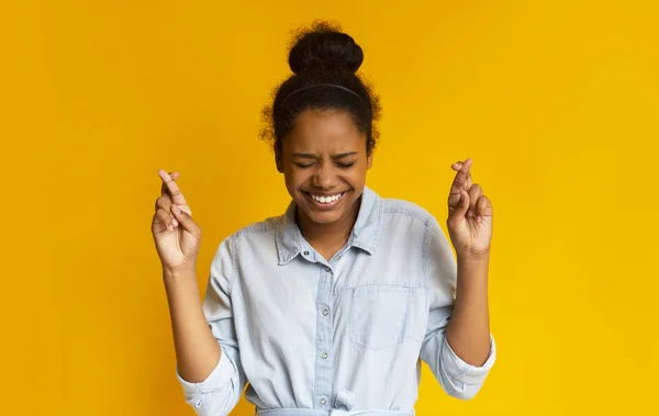 African teenager crossing fingers wishing, praying for miracle