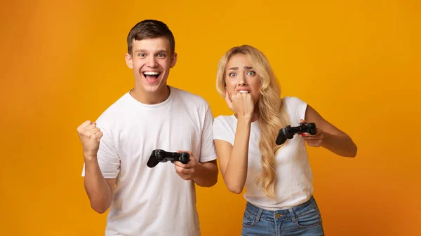 Gambling couple playing video game with joysticks