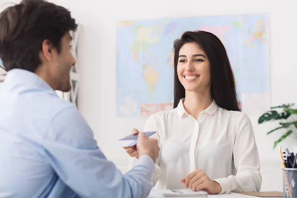 Tour agent het geven van paspoort met visa aan de mens — Stockfoto