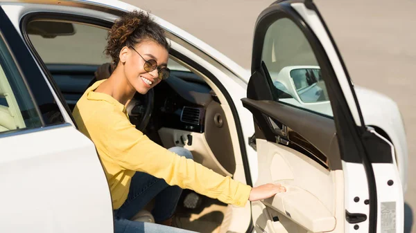 Mujer afro feliz saliendo del coche, abriendo la puerta — Foto de Stock