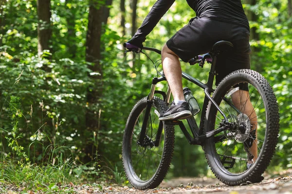 Nogi rowerzysty jeżdżąc rowerem w lesie — Zdjęcie stockowe
