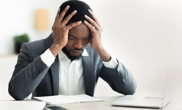 Afro zakenman die aan hoofdpijn lijdt, zijn tempel aanraakt — Stockfoto