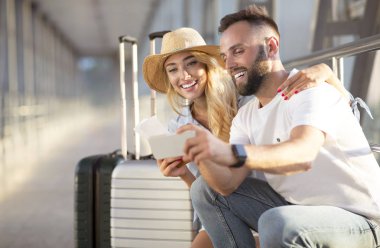 Telefon kullanan çift, havaalanında görüntülü görüşme yapıyor