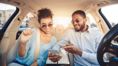 Genç çift araba sürme ve dijital harita kullanarak