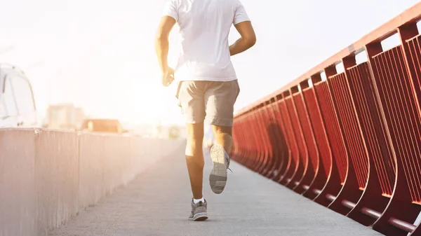 Abgeschnittenes Bild eines sportlichen Afro-Mannes, der auf Brücke rennt — Stockfoto