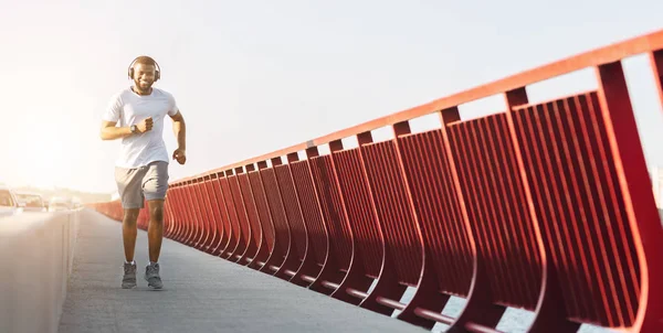 Atlético afro chico disfrutando jogging por puente —  Fotos de Stock