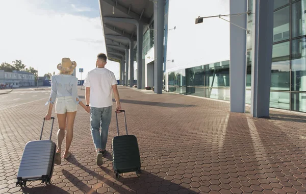 Havaalanında yürüyen genç çift, seyahat ve turizm