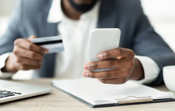 Seorang pria menggunakan kartu kredit dan smartphone untuk berbelanja di internet — Stok Foto