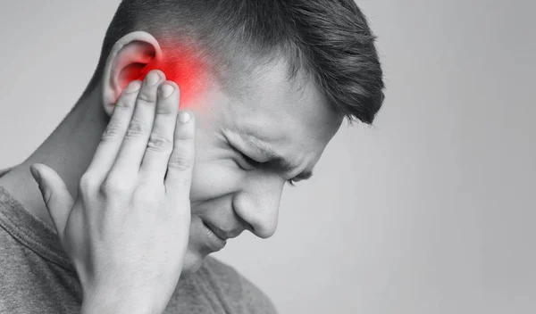 Sick man having ear pain, touching his painful head — Stock Photo, Image