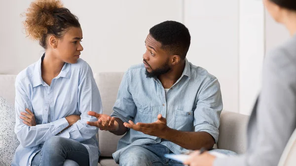 Afro Marido conversando com esposa sentada no escritório de terapeutas de casais — Fotografia de Stock