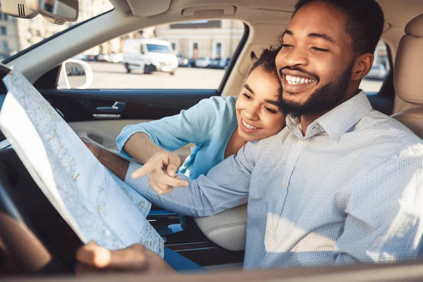 Jovem casal feliz com mapa no carro — Fotografia de Stock