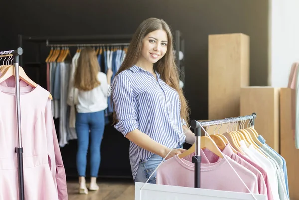Glimlachend meisje het kiezen van nieuwe trui in de winkel — Stockfoto