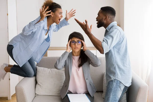 Psicoterapeuta sorprendido viendo cónyuges negros gritando y culpándose mutuamente —  Fotos de Stock