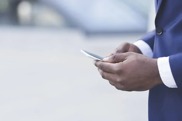 Primer plano de los hombres de negocios afro usando el teléfono celular en el área urbana — Foto de Stock