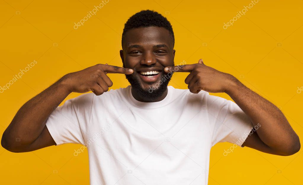 Young african american man smiling and showing perfect teeth