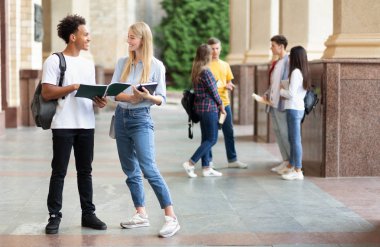 Üniversite kampüsünde kitap la eğitim alan öğrenciler