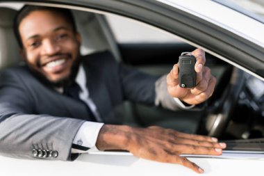 Araba sahibi. Mutlu adam anahtar gösteren, otomatik oturan