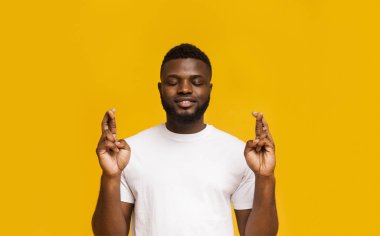 Dileğini gerçekleştir. Neşeli adam şans için parmaklarını geçiyor