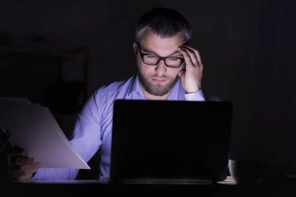 Empresario barbudo está haciendo el trabajo de papel delante de la computadora portátil —  Fotos de Stock