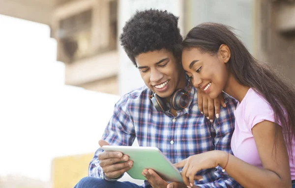 Jovem casal navegando nas mídias sociais em tablet digital ao ar livre — Fotografia de Stock