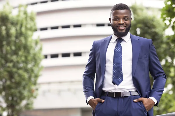 Handsome black man in suit against modern office center background