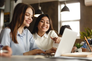 Eğitim kavramı. Kütüphanede dizüstü bilgisayar ile mutlu öğrenciler