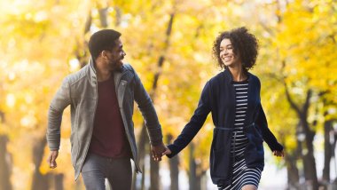 Sonbahar parkında eğlenen sevgi dolu çift