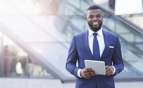 Joyeux homme d'affaires afro-américain tenant tablette numérique dans l'espace urbain — Photo