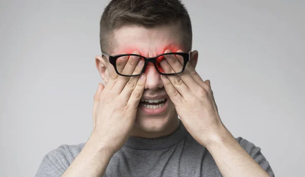 Young man suffering from pain in eyes after work with computer — Stock Photo, Image