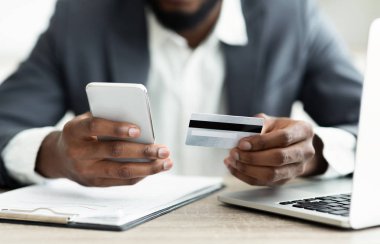 Ciddi işadamı akıllı telefon uygulaması kullanarak faturalarını online ödeme