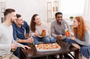 Ev partisi. Mutlu arkadaşlar pizza yiyip bira içiyorlar.