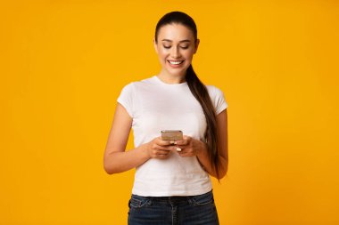 Neşeli Kız Sarı Arka Planda Cep Telefonu Kullanarak Arkadaşlar ile Sohbet