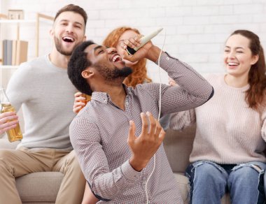 Genç adam mikrofon tutan ve karaoke de şarkı