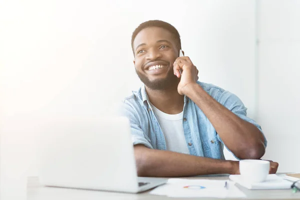 Uma chamada satisfatória. Jovem empresário falando telefone e trabalhando no laptop — Fotografia de Stock