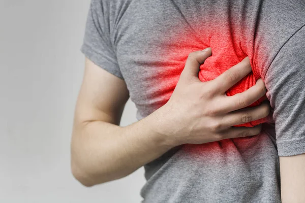 Καυκάσιος άνθρωπος που έχει καρδιακό πόνο, κρατώντας το χέρι στο στήθος — Φωτογραφία Αρχείου