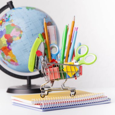 Beyaz kırtasiye ile dünya küre ve alışveriş sepeti