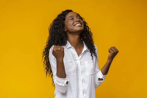 Zwart meisje glimlachend en het verhogen van gebalde vuisten in de lucht — Stockfoto