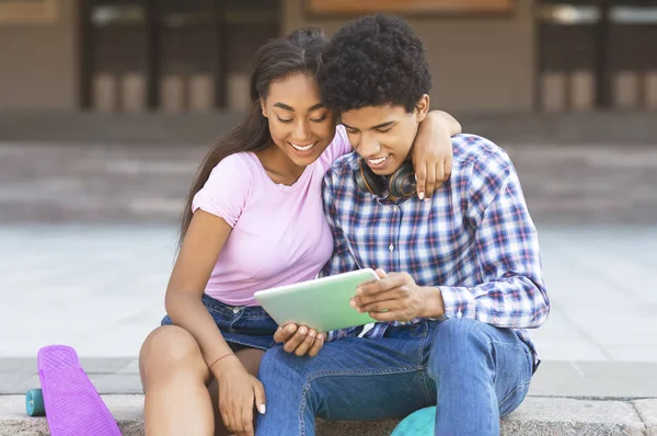 Dunkelhäutige Teenager, die Videos auf einem digitalen Tablet im Freien ansehen — Stockfoto