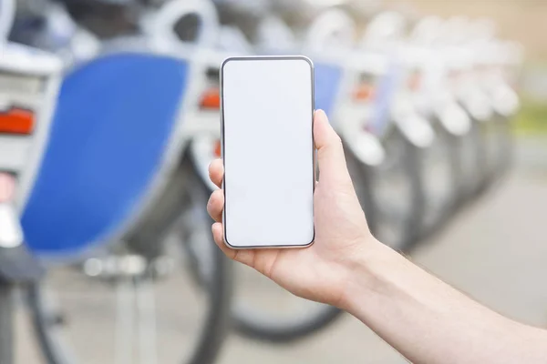 Uomo che mostra cellulare con applicazione mobile per il servizio di noleggio biciclette — Foto Stock