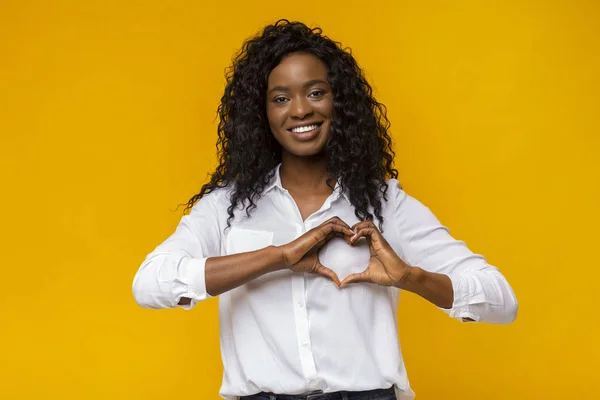 Vrolijke Afro vrouw die de handen als hart op de camera vormgeeft — Stockfoto