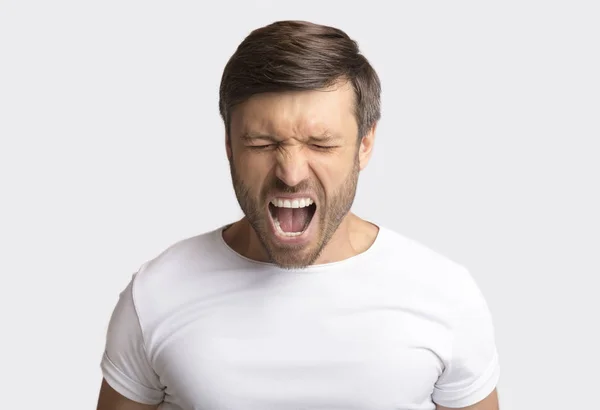 Retrato de hombre emocional gritando furiosamente sobre fondo blanco —  Fotos de Stock