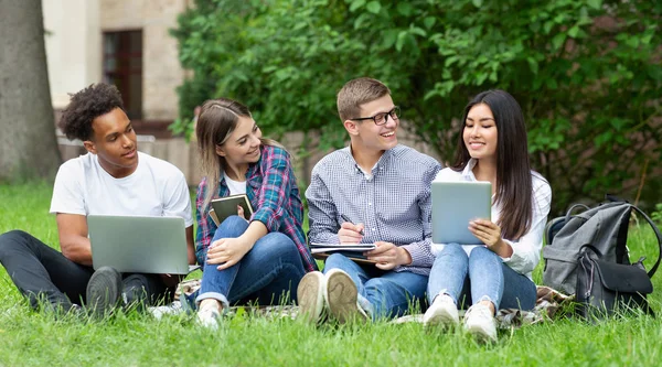 Koncepcja edukacyjna. Studenci z urządzeniami przygotowywani do egzaminów — Zdjęcie stockowe