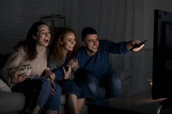 Amigos emocionados viendo la televisión y cambiando de canal —  Fotos de Stock