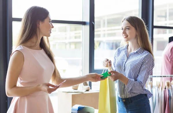 Jonge dame betalen met creditcard voor aankopen bij Boutique — Stockfoto