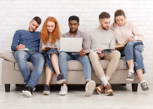 Diversos amigos estudando juntos, usando laptop e livros — Fotografia de Stock